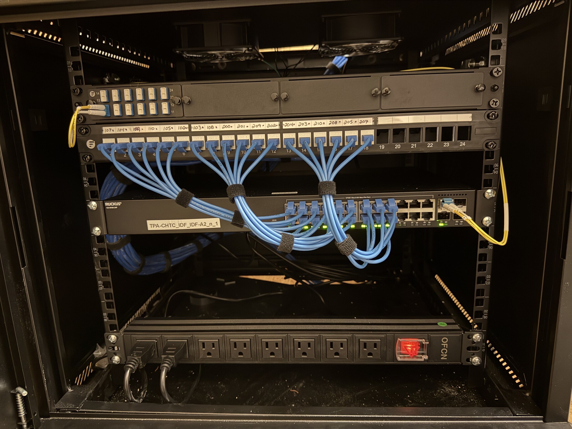 Completed IDF network rack with organized fiber and copper patching at a Kissimmee multifamily property