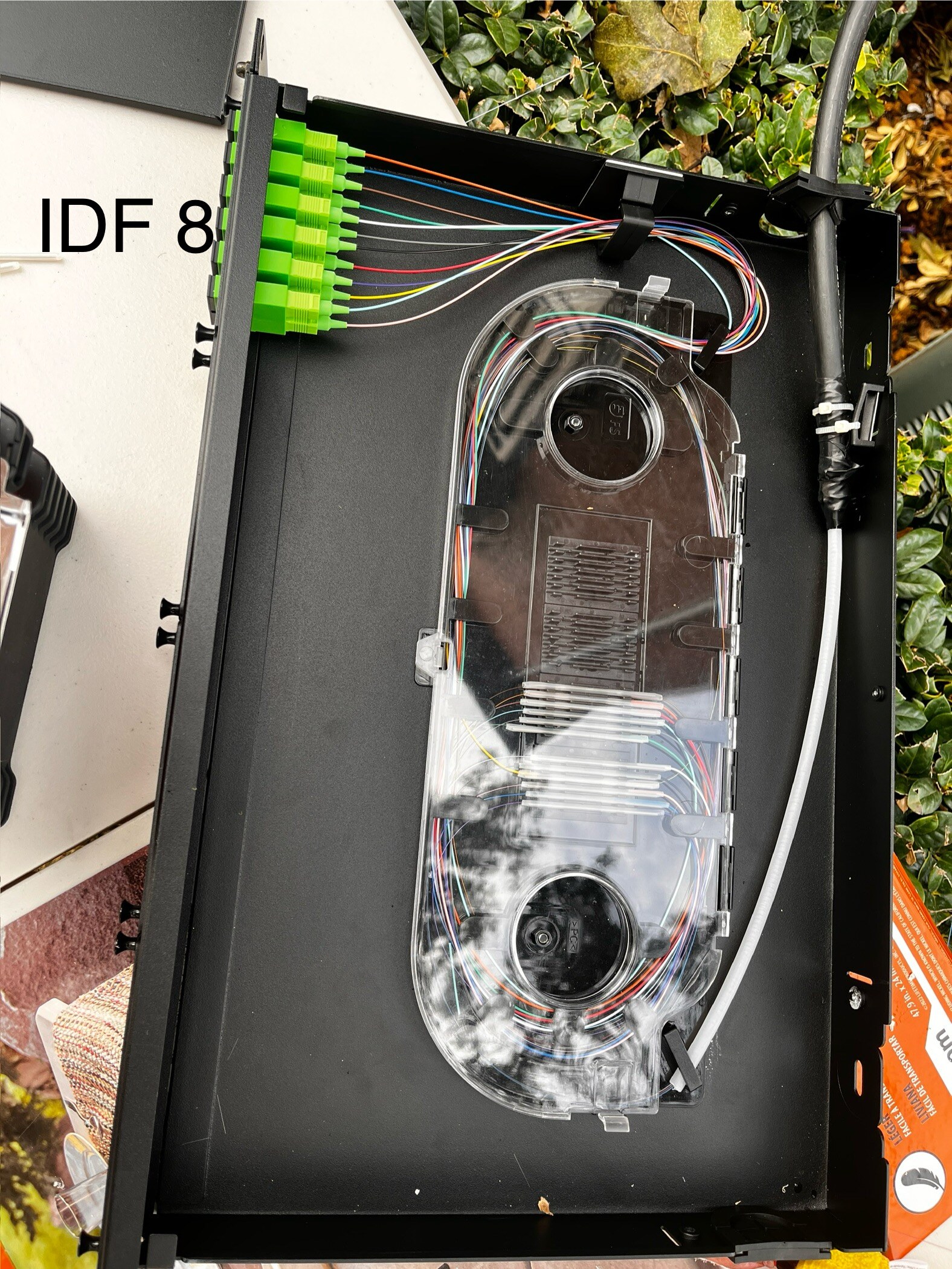 Organized fiber strands and adapters inside an IDF splice enclosure